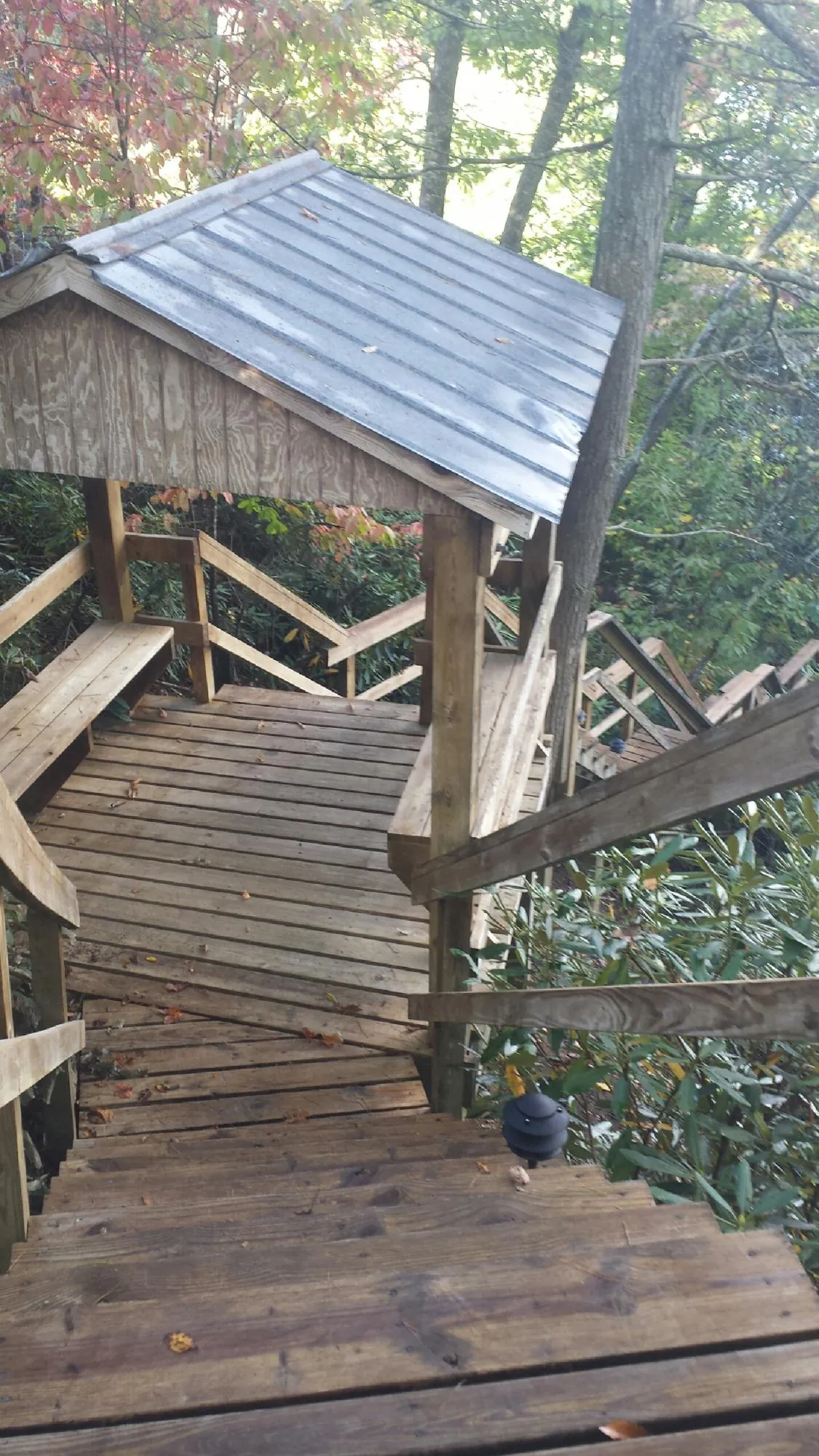 Metal roofed shelter over wooden steps on a wooded walkway — Skylight Repair & Installation work by our crew in Guysville