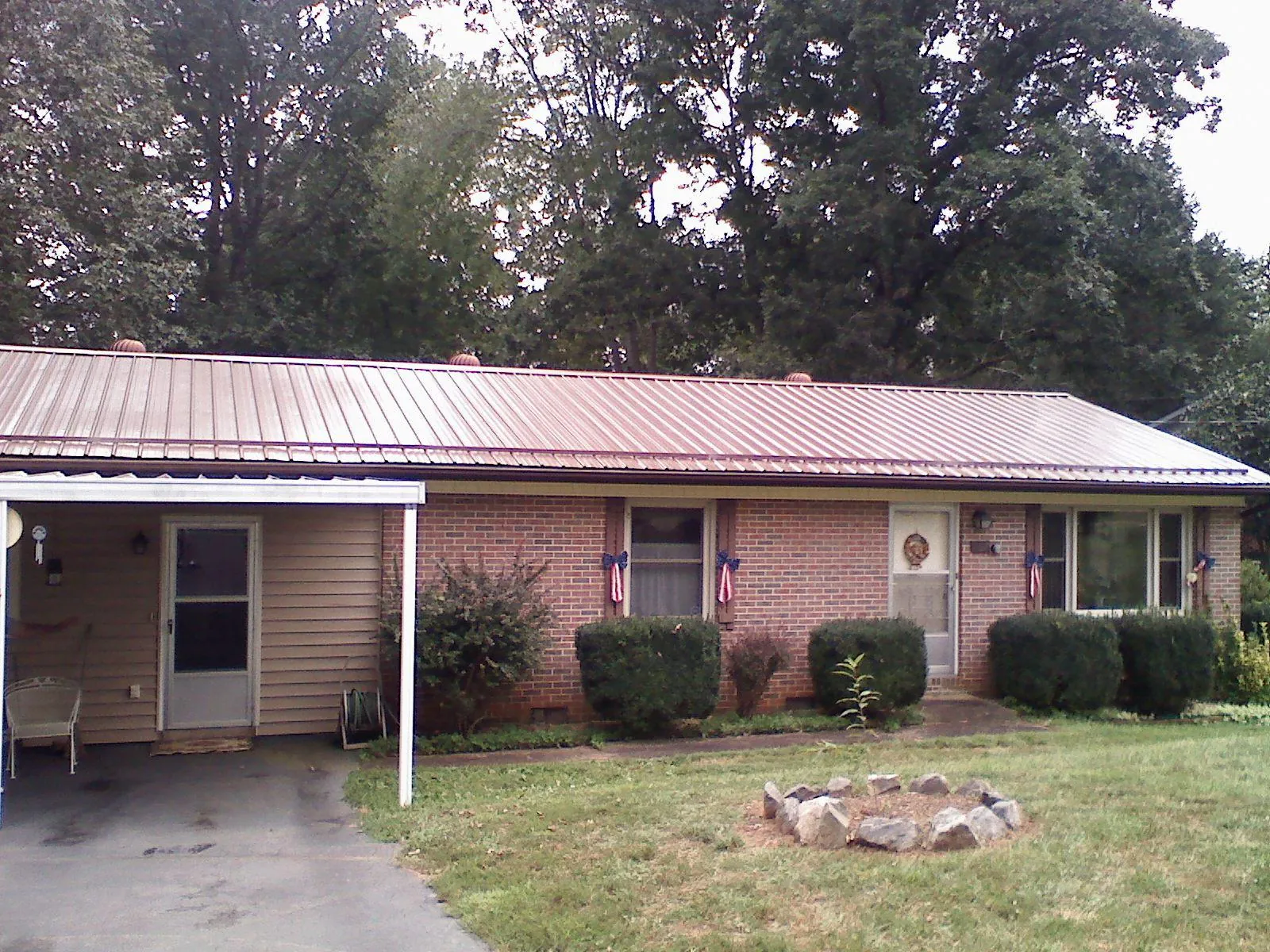Bronze metal roof and carport on a brick ranch home — Roof Repair work by our crew in Guysville